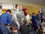 Teacher getting into metal suit